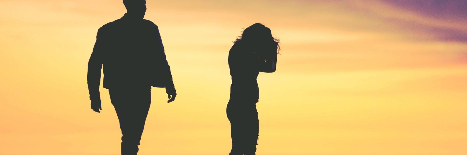 silhouette of man and women against sunset background